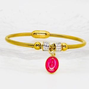 Détail macro du bracelet maille serpent doré avec pendentif religieux en émail rose