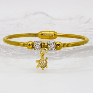 Detail of gold snake chain bracelet with magnetic clasp and crystal turtle charm