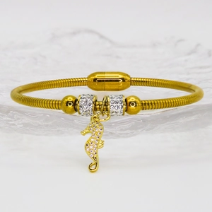 Macro shot of gold seahorse pendant bangle with crystal pavé and magnetic buckle