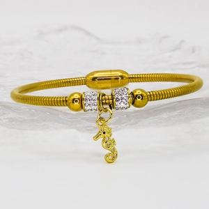 Close-up of golden seahorse pendant bracelet with shimmering rhinestones and snake chain