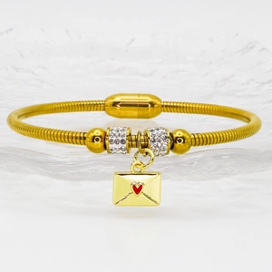 Details des goldenen Magnetarmbands mit Umschlag-Anhänger und rotem Herz