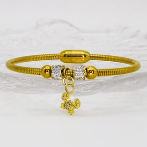 Macro shot of gold crab pendant with micro-inlaid crystals and textured steel band