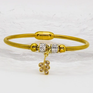 Gold-plated magnetic bangle with sparkling crystal flower pendant on glass plate