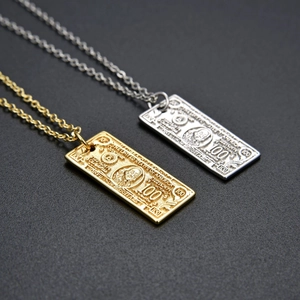 Close-up of gold and silver 100 dollar bill pendants with detailed engraving