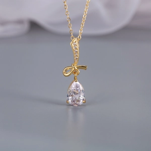 Elegante collana a fiocco dorata con ciondolo in zirconia a goccia e micro-cristalli