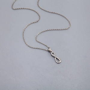 Nahaufnahme des Unendlichkeits-Anhängers mit Zirkonia-Inlay und feiner silberfarbener Kette