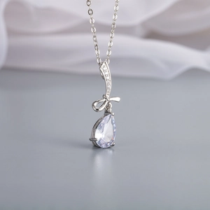 Dettaglio della collana in argento con fiocco e pendente in zircone a goccia e catena fine