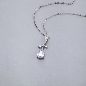 Dettaglio della collana con pendente a goccia in zircone viola e fiocco in argento