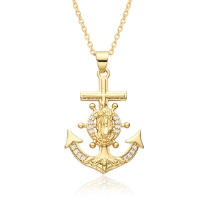 Macro shot of 18k gold plated anchor and cross pendant with zircon inlays and Virgin Mary
