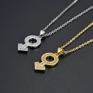 Detail van zilveren en gouden Mars symbool kettingen met zirkonia steentjes ingelegd