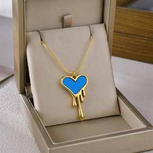 Melting gold heart pendant with electric blue enamel on a sleek snake bone chain