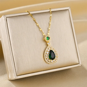 Collana di lusso in titanio dorato con ciondolo a goccia smeraldo e cristalli micro-pave