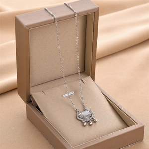 Detail of silver ruyi lock pendant with cat eye stone and cubic zirconia on silk