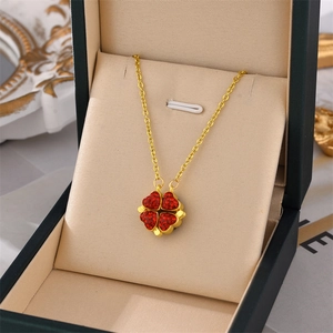 Golden titanium steel folding clover necklace with red crystals in a jewelry box