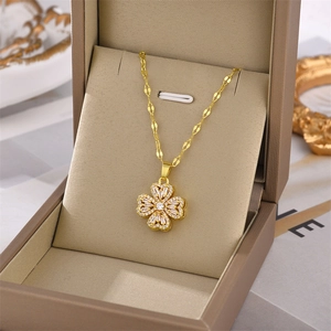 Macro shot of gold clover pendant with micro-pave crystals on a specialized metal chain