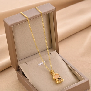 Golden bear pendant necklace with orange gemstone in a luxury jewelry gift box