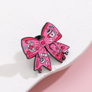 Détails d'un pin's nœud rose en émail avec stéthoscope et icônes médicales