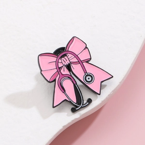 Vue détaillée d'une broche stéthoscope à nœud rose en émail avec un fermoir en caoutchouc