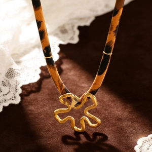 Nahaufnahme des goldenen Blumenanhängers mit Leopard-Stoffhalskette für Damen