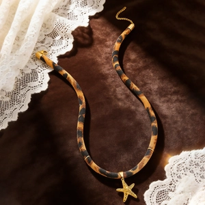 Detail eines Chokers mit Leopardenmuster und goldenem Seestern auf Samtstoff