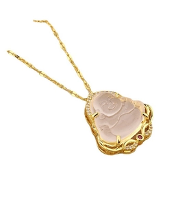 Detailed macro view of gold Buddha pendant with pink gem and sparkling white crystals
