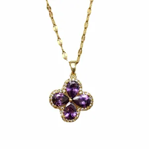 Detailed close-up of violet zircon clover pendant with gold chain and white diamond trim