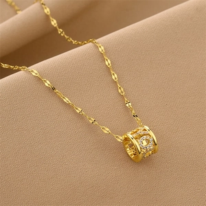 Vue macro du collier avec pendentif cylindre doré serti de zircons cubiques brillants