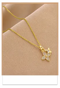 Détail d'un collier doré avec pendentif double papillon sur un tissu texturé élégant