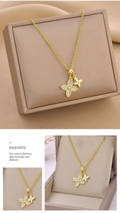 Gros plan du collier trèfle doré avec zircons blancs sur un coffret à bijoux