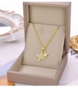 Gros plan du pendentif trèfle doré avec zircons blancs sur un coffret à bijoux de luxe