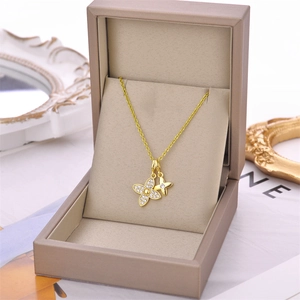 Élégant collier double trèfle doré avec incrustation de zircons dans un écrin de luxe