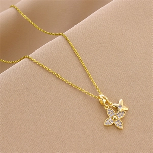 Collier à double trèfle doré élégant avec zircons cubiques sur fond de soie