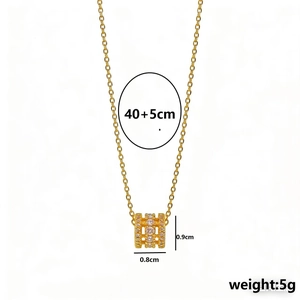 Collier élégant en acier au titane doré avec un pendentif cylindrique pavé de cristaux
