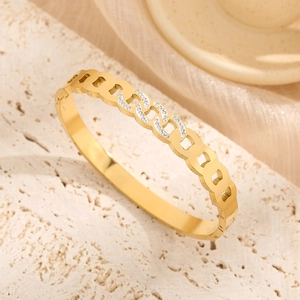 Elegant gold twisted chain bangle with white zircon pavé setting on a stone display