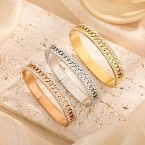 Three-color titanium steel cuban link bracelets with pavé zircons on stone display