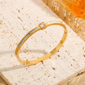 Gold plated cuff bracelet with square zircon and shell inlay on textured stone