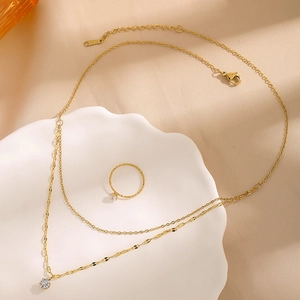 Double-layered gold stainless steel necklace and ring set with a sparkling zircon pendant