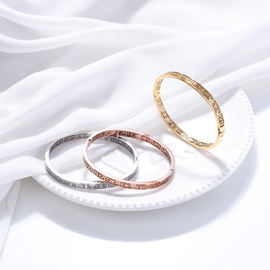 Detailed view of titanium steel bracelets with Greek key pattern in gold and silver