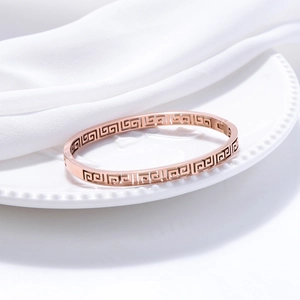 Rose gold Great Wall pattern cuff bracelet in hollow design on white silk background