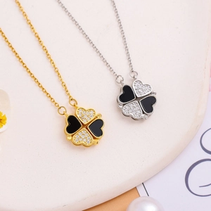 Detail of magnetic folding clover necklace in gold and silver with black enamel and zircon