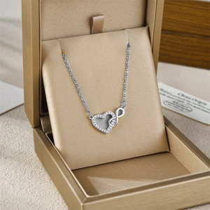Micro-paved heart and infinity necklace in silver, elegantly set on champagne satin