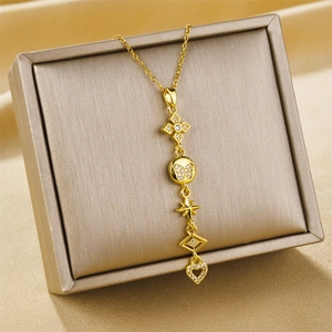 Gold-tone necklace with clover star and heart pendants displayed on luxury jewelry box
