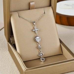 Silver drop necklace with clover, butterfly, and heart charms in a premium gift box