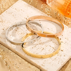 Detailed close-up of 18k gold plated stainless steel bangles with starburst zircon inlay