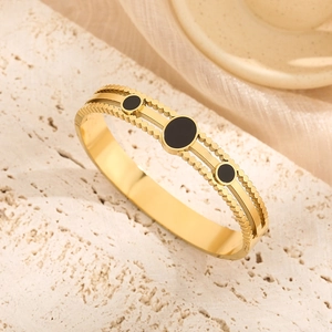 Golden titanium steel hinged bracelet with black enamel accents and retro beaded edge detail