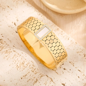 Vintage gold plated honeycomb bangle with shell inlay and crystal halo on marble surface