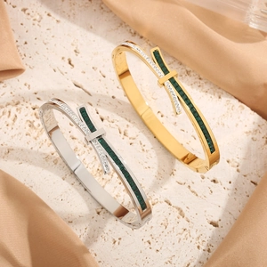 Close-up of bow knot titanium steel bracelets with green gems and white zircons