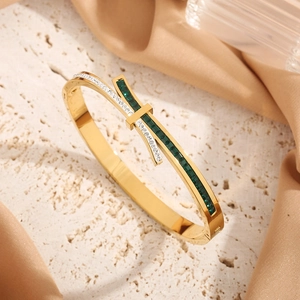 Gold titanium steel bow bracelet featuring green rectangular stones and crystal accents