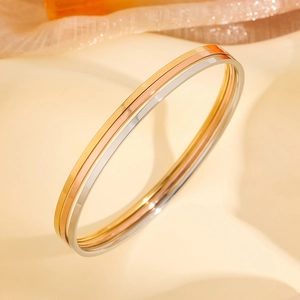 Three-piece set of polished stainless steel minimalist bangles in gold, silver, and rose gold