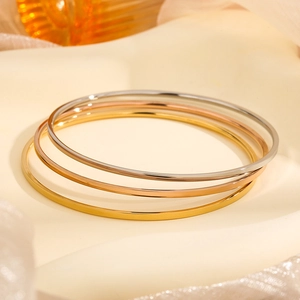 Polished minimalist stainless steel bangles in gold, rose gold, and silver finishes